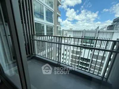 Modern apartment balcony with city view and glass railing, perfect for urban living.