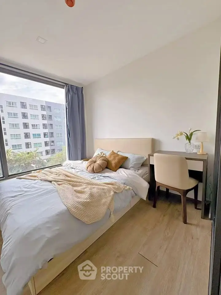 Cozy bedroom with large window and modern decor in urban apartment