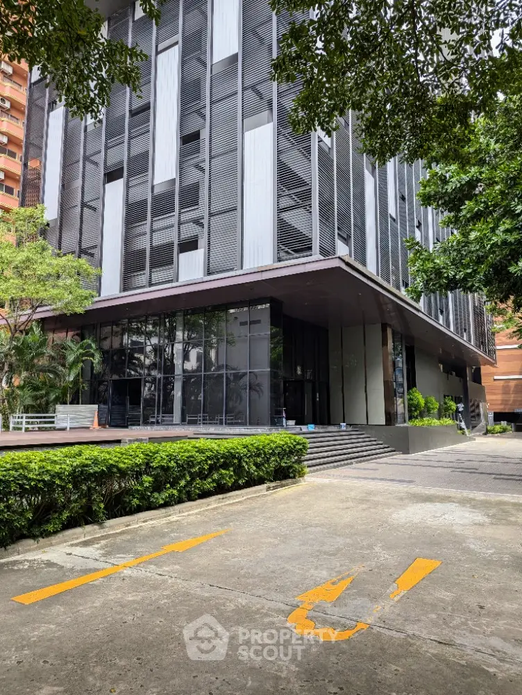 Modern commercial building exterior with sleek design and lush greenery