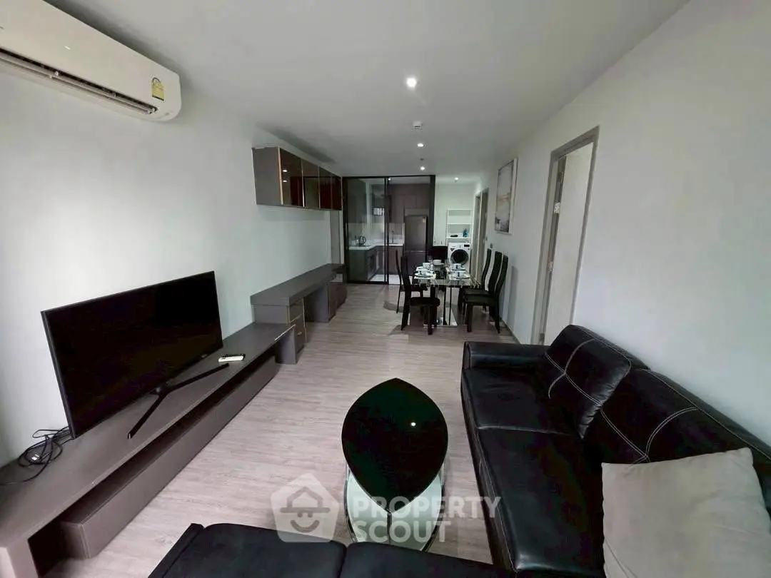 Modern living room with sleek black furniture and open layout