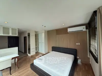 Spacious bedroom with modern furnishings and natural light in a stylish apartment.