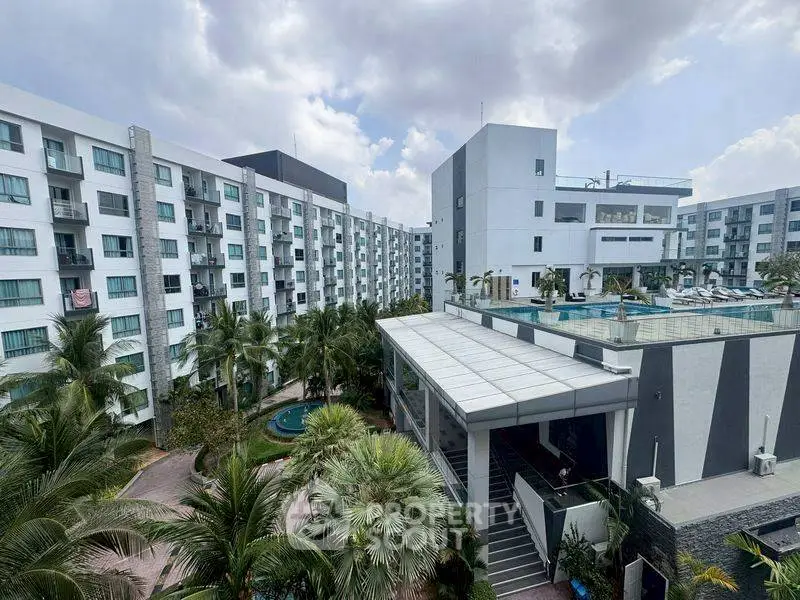 Modern apartment complex with lush landscaping and pool view