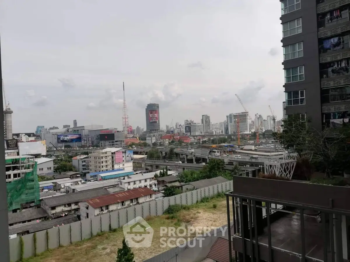 Urban cityscape view from a high-rise building with skyline and construction cranes.