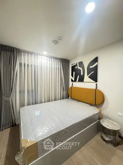 Modern bedroom with stylish decor and natural light, featuring a comfortable bed and elegant curtains.