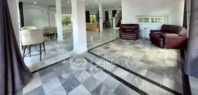 Spacious open-plan living area with modern tiled flooring and elegant furnishings.