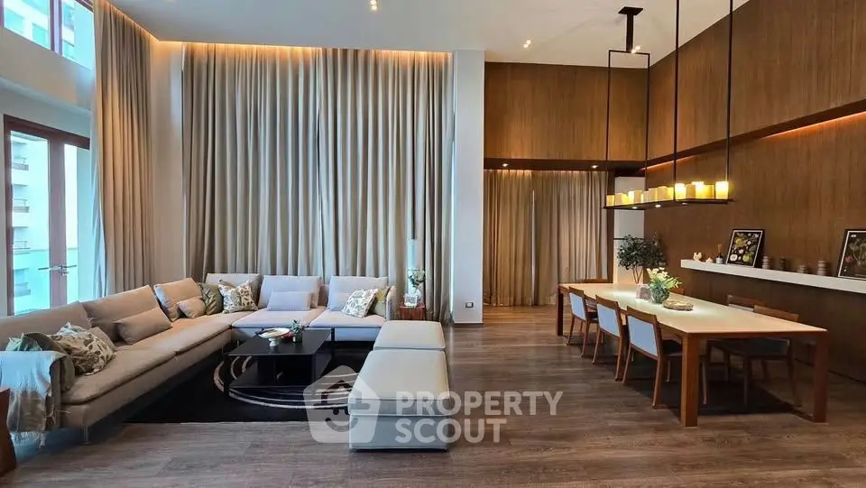 Luxurious modern living room with high ceilings and elegant dining area, featuring stylish furniture and ambient lighting.