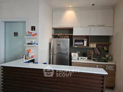 Modern kitchen with sleek cabinetry and appliances, featuring a compact open layout and stylish breakfast bar.