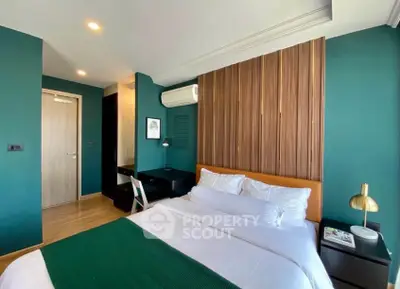 Modern bedroom with green accent wall and stylish decor in a contemporary apartment.