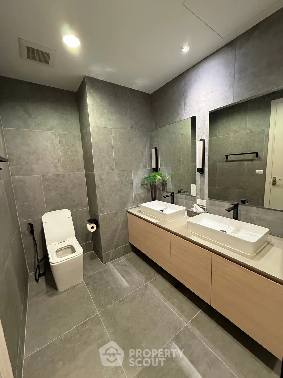 Modern bathroom with dual sinks and sleek gray tile design