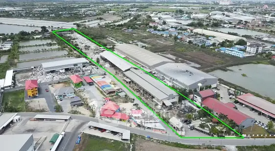 Aerial view of industrial property with large warehouses and surrounding landscape.