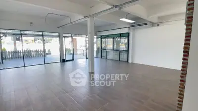 Spacious commercial space with large windows and modern flooring, ideal for retail or office use.