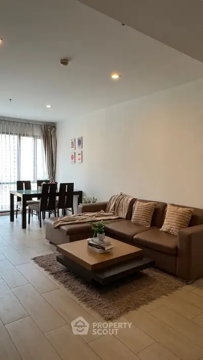 Spacious living room with modern furniture and dining area, perfect for family gatherings.