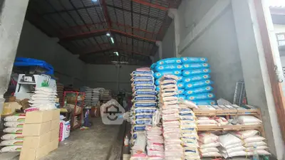 Spacious warehouse interior with stacked goods and high ceiling, ideal for storage or distribution.