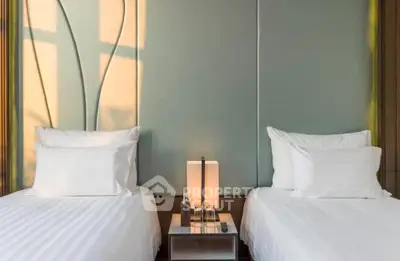 Modern bedroom with twin beds and elegant lighting, perfect for a cozy and stylish retreat.