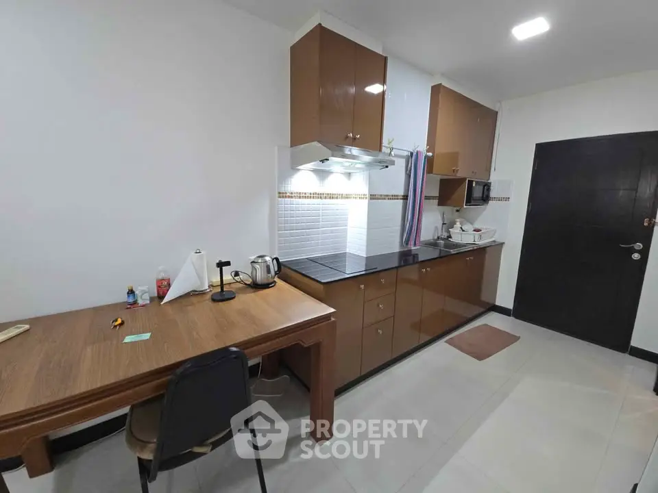Modern kitchen with sleek cabinets and dining table, perfect for culinary enthusiasts.