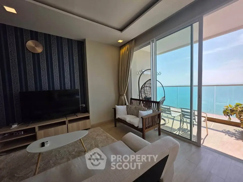 Stunning living room with ocean view balcony, modern decor, and natural light.