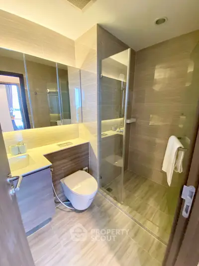 Modern bathroom with sleek design, glass shower, and elegant fixtures in a contemporary apartment.