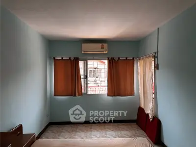Spacious bedroom with air conditioning and large window for natural light.