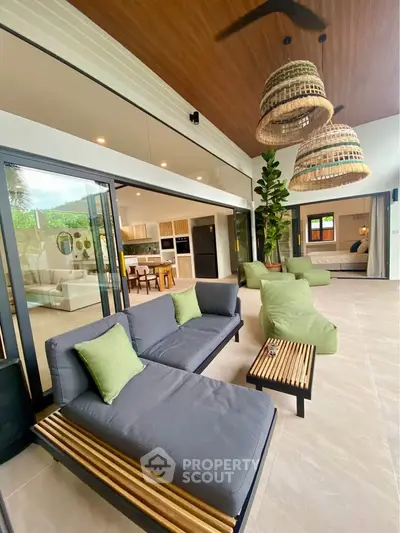 Luxurious open-plan living room with modern furniture and seamless indoor-outdoor flow.