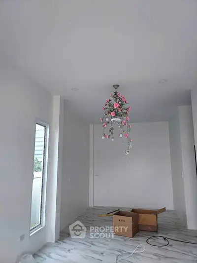 Spacious interior with elegant chandelier and marble flooring, perfect for modern living.