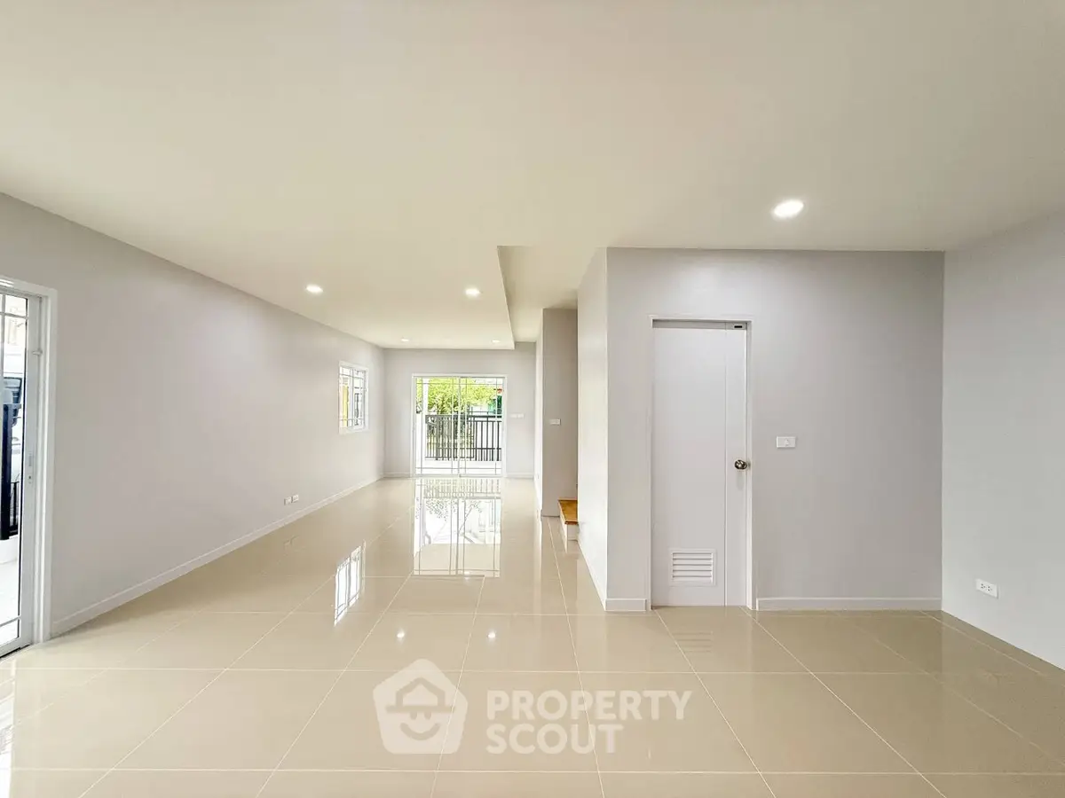 Spacious modern living room with glossy tiled floors and ample natural light