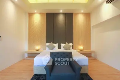 Luxurious modern bedroom with elegant decor and cozy seating area.