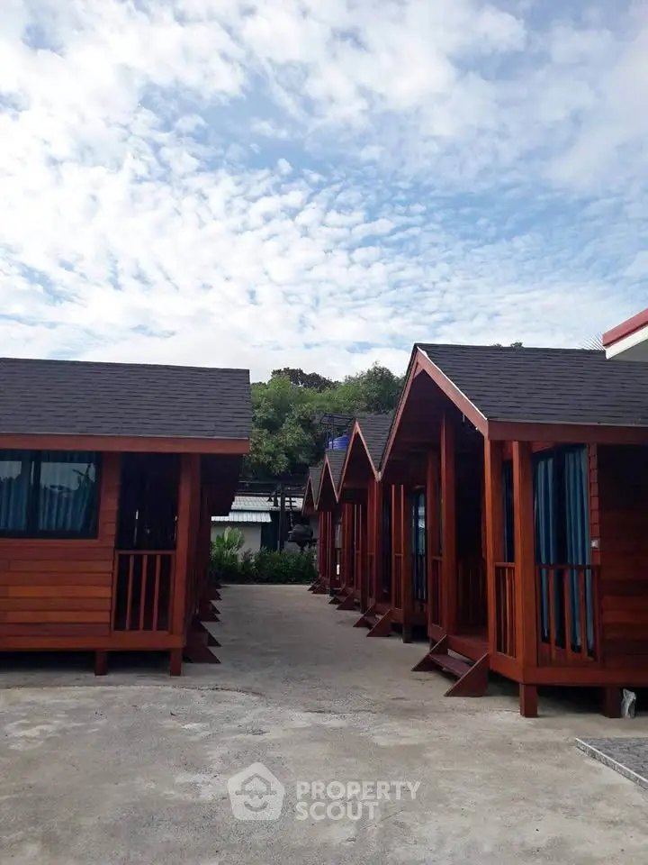Charming row of wooden cabins with pitched roofs under a clear blue sky.