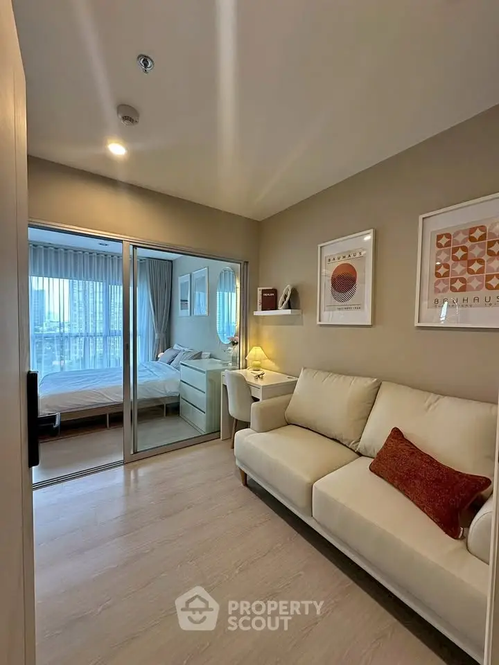Cozy modern living room with adjacent bedroom, featuring stylish decor and natural light.