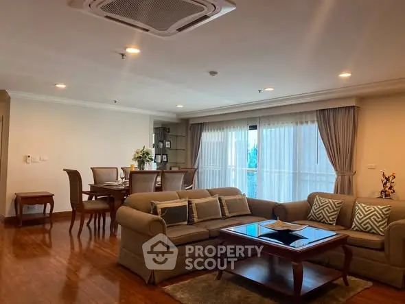 Spacious living room with elegant furniture and large windows in a modern apartment.