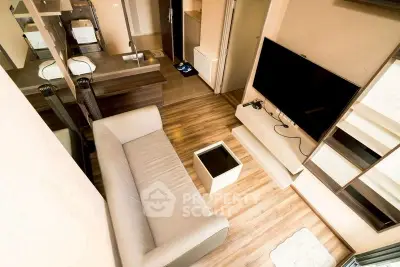 Modern living room with sleek design, featuring a comfortable sofa, large TV, and stylish wooden flooring.