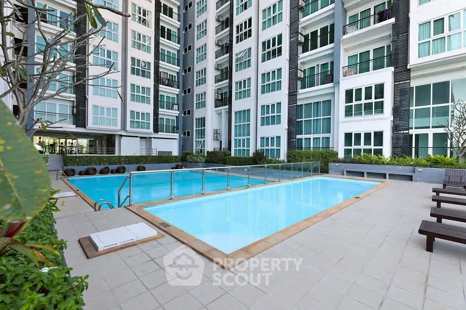 Modern apartment complex with inviting outdoor swimming pool and lush greenery.