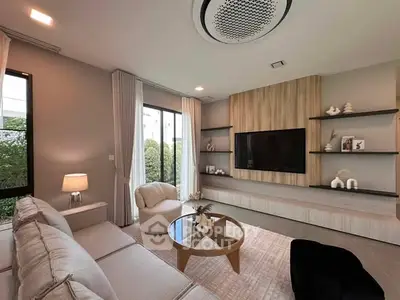 Modern living room with stylish decor and large TV, featuring cozy seating and elegant lighting.