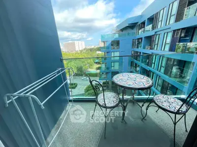 Chic balcony with stylish seating and stunning city view in modern blue building.
