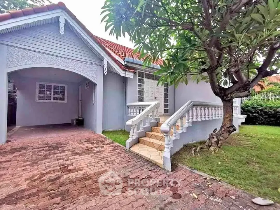 Charming single-story home with red-tiled roof and lush garden, perfect for family living.
