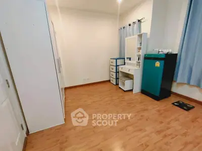 Spacious bedroom with wooden flooring and ample storage in modern apartment.
