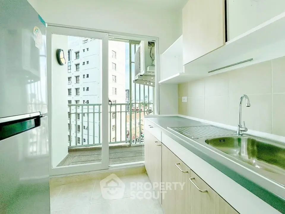 Modern kitchen with balcony view in high-rise apartment