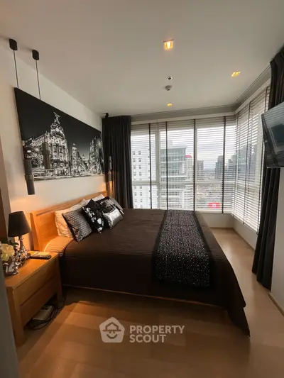 Luxurious bedroom with city view, modern decor, and large windows for natural light.