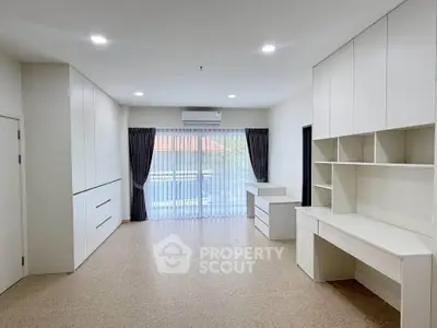 Spacious modern living room with built-in storage and large windows for natural light.