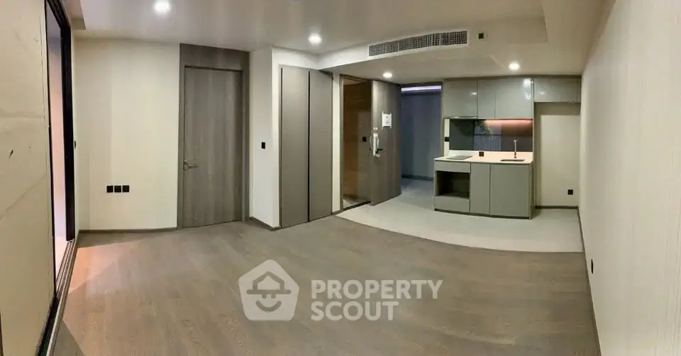 Modern open-plan living room with sleek kitchen design and wooden flooring