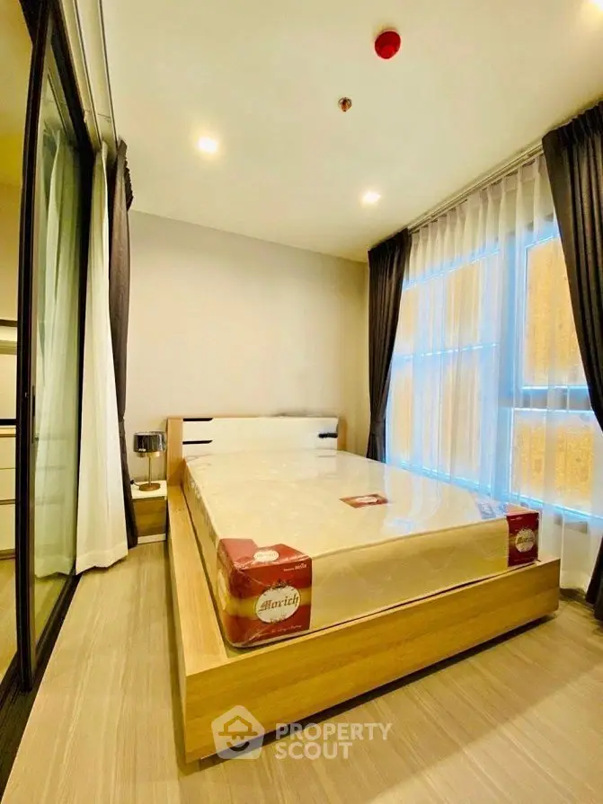 Modern bedroom with large windows and elegant decor in a stylish apartment.