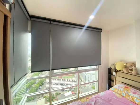 Cozy bedroom with large windows and city view, featuring modern blinds and plush decor.