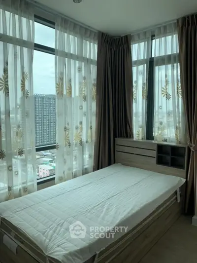 Cozy bedroom with large windows and stylish curtains offering city views.