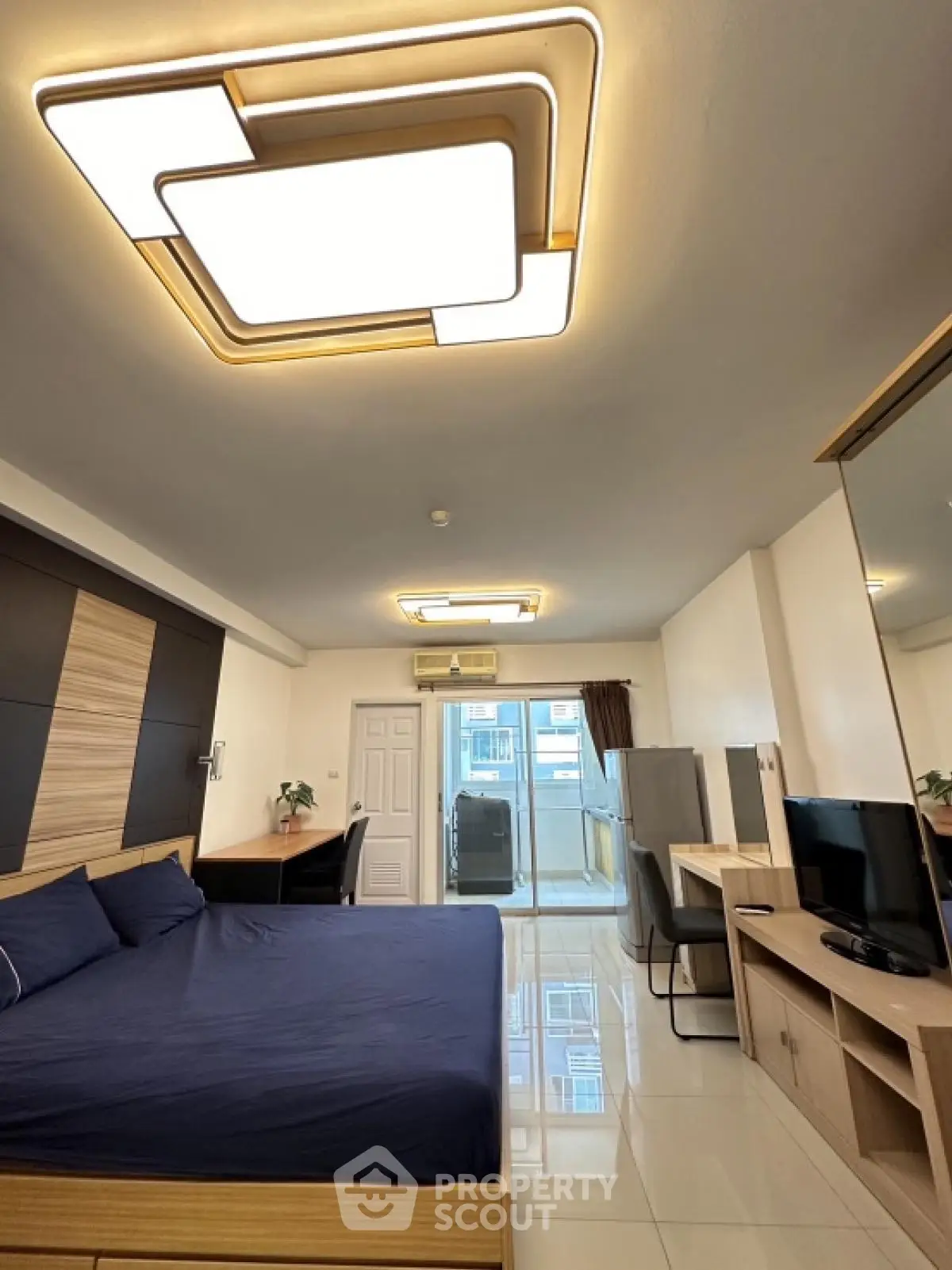 Modern bedroom with stylish ceiling lights and sleek furniture, featuring a cozy workspace and large window.
