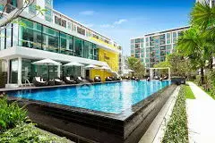 Luxurious modern apartment complex with stunning pool and lush landscaping.