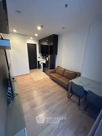 Modern living room with sleek kitchen and cozy seating area