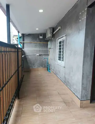 Spacious balcony with modern tiles and railing, perfect for outdoor relaxation.