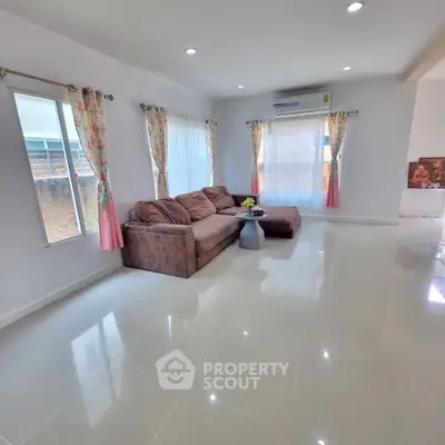 Spacious living room with modern sofa and large windows for natural light.