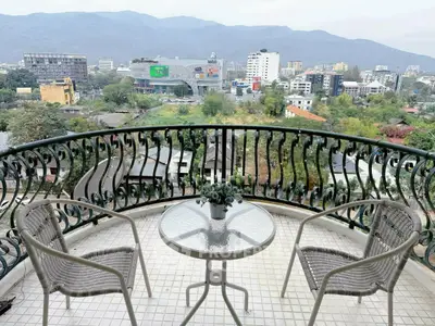 Stunning balcony view with elegant railing overlooking cityscape and mountains, perfect for relaxation.