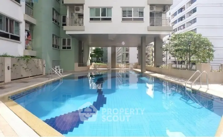 Luxurious residential building with a pristine swimming pool and modern architecture.