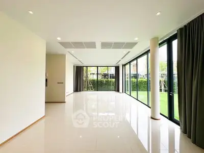 Spacious modern living room with large windows and garden view